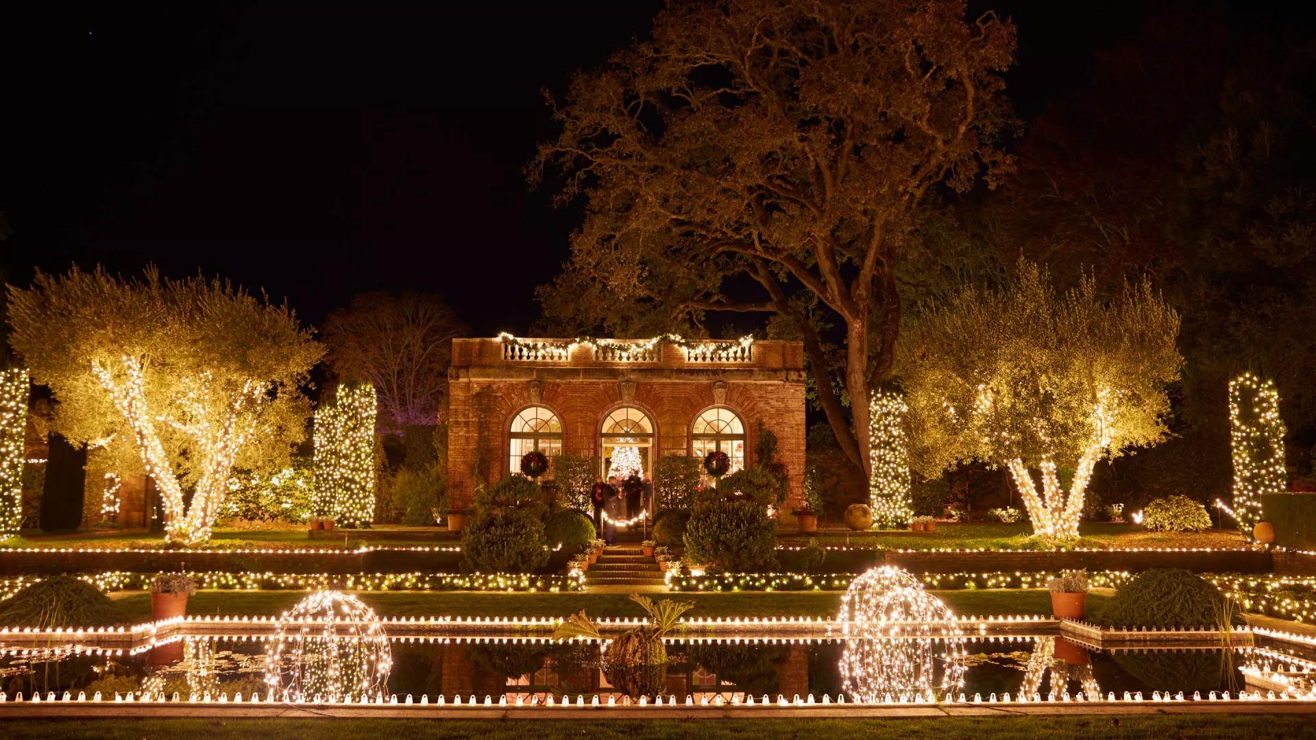 Large manor house is lit up by lights at night