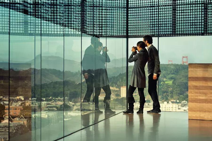两个人在贝博体彩app杨格博物馆的玻璃墙下凝视着.