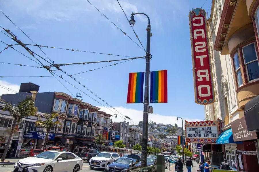 The Castro neighborhood of San Francisco, with the Castro Theater sign and rainbow flags in the foreground.