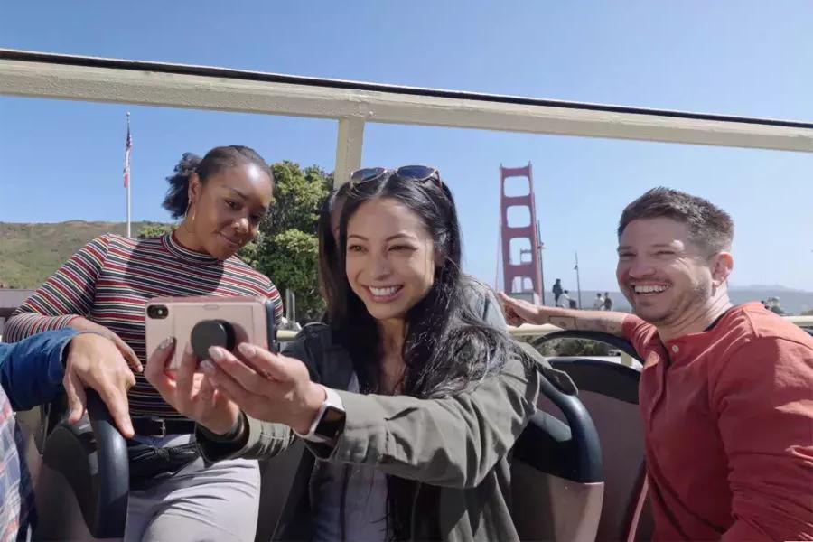 Un groupe de visiteurs prend un selfie lors d'une visite en bus près du Golden Gate Bridge. San Francisco, Californie.