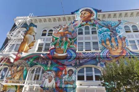 Un murale colorato e di grandi dimensioni copre il lato del Women's Building nel Mission District di San Francisco.