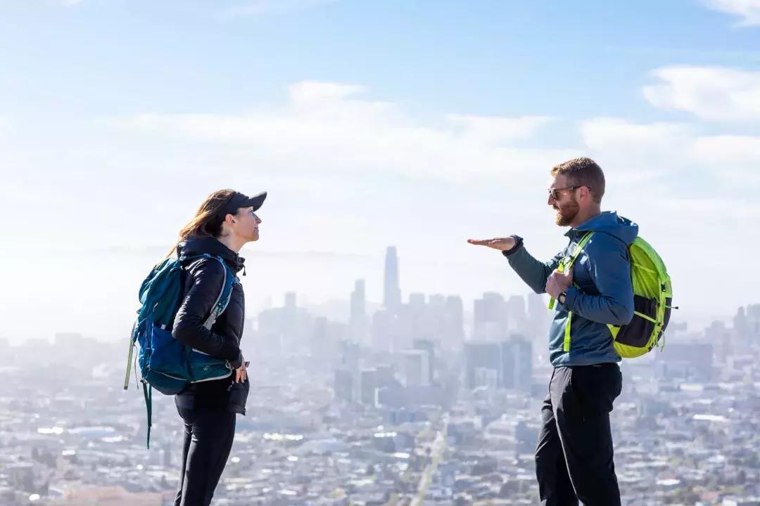 Hikers chatting with the San Francisco skyline in the distance