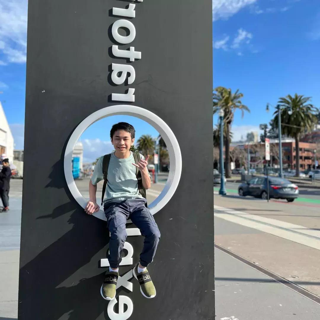 Child sitting on Exploratorium sign 