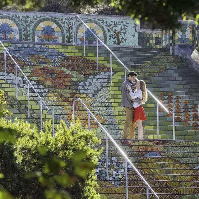 Photo taken from an angle of a couple standing on Lincoln Park's colorful tiled steps